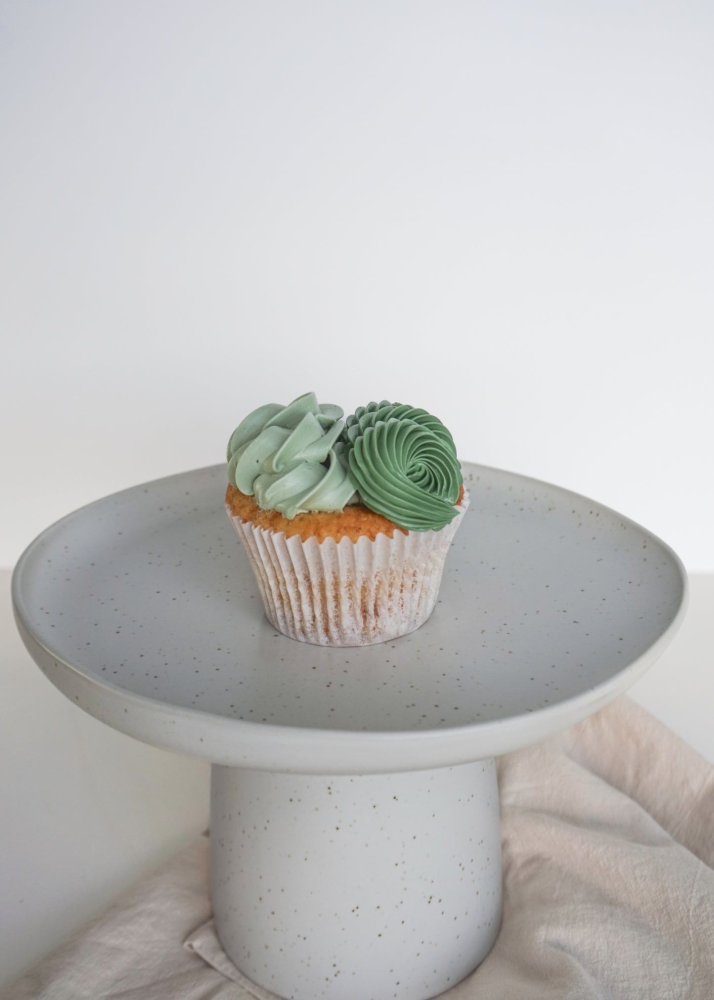 cupcake on a stand with green buttercream
