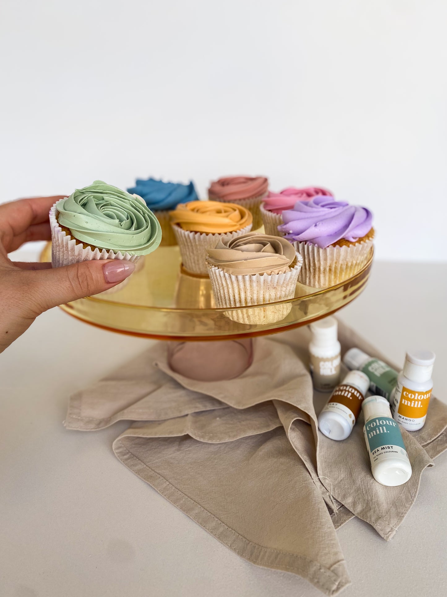 tray of multicoloured cupcakes
